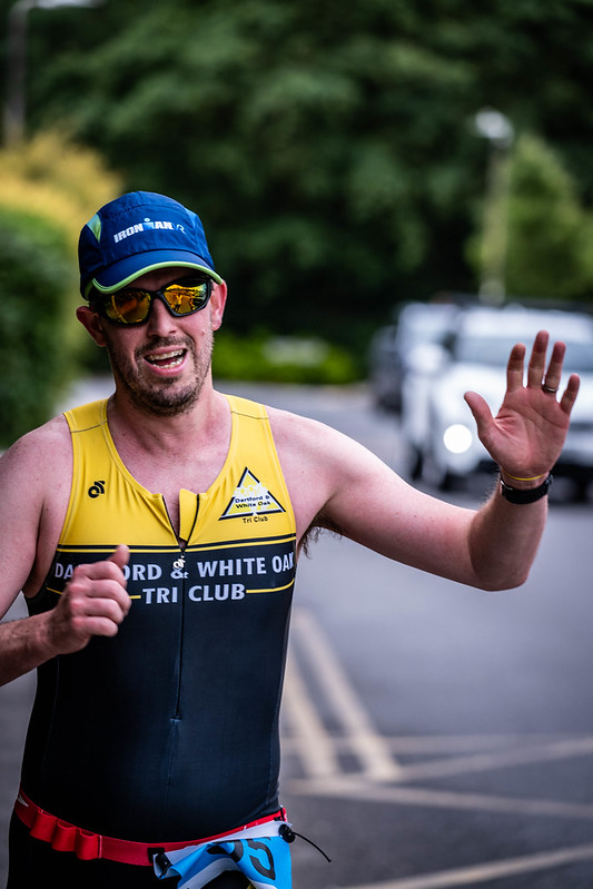 Club runner waving mid-race